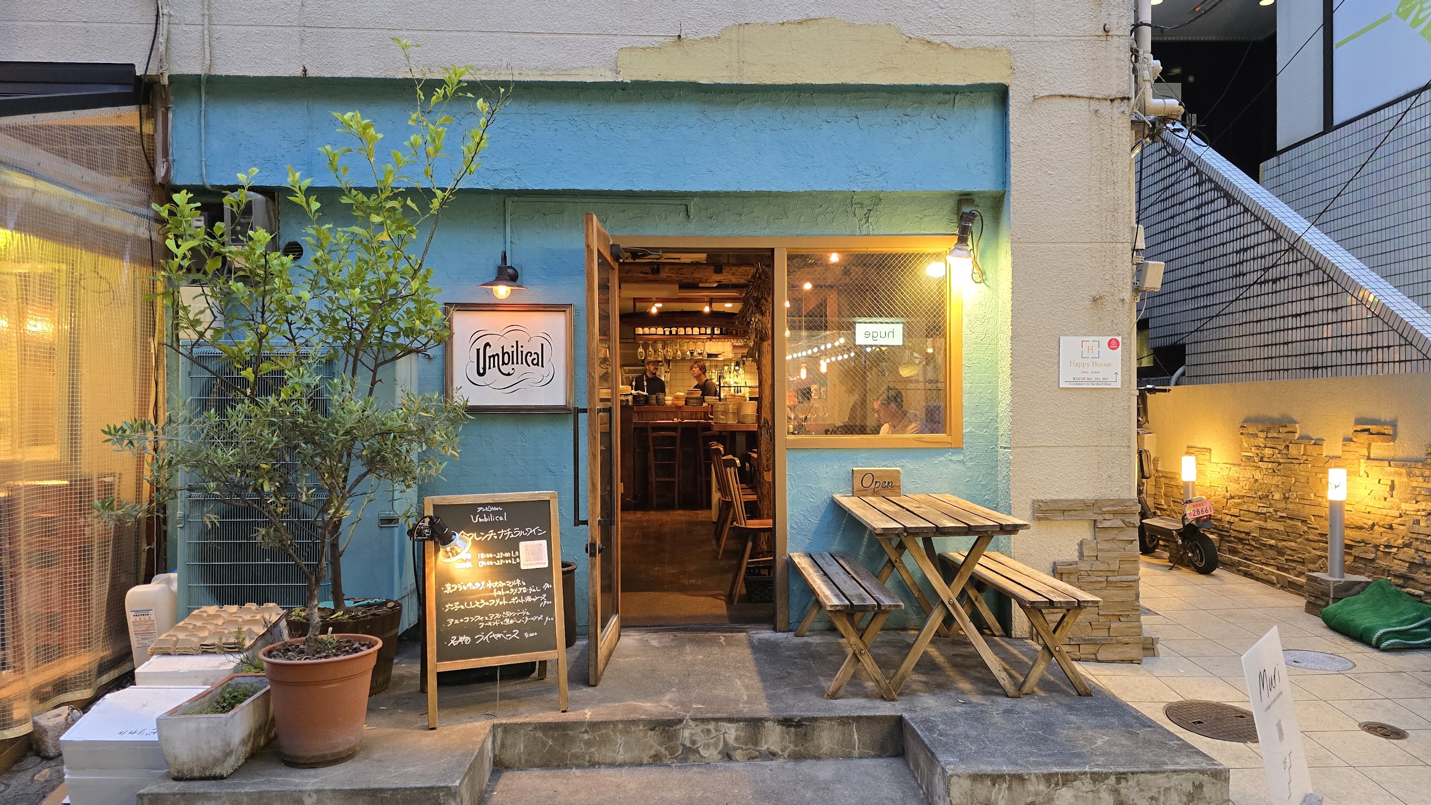 横長 16:9 の構図で写された店内、料理が並ぶテーブルの一場面
