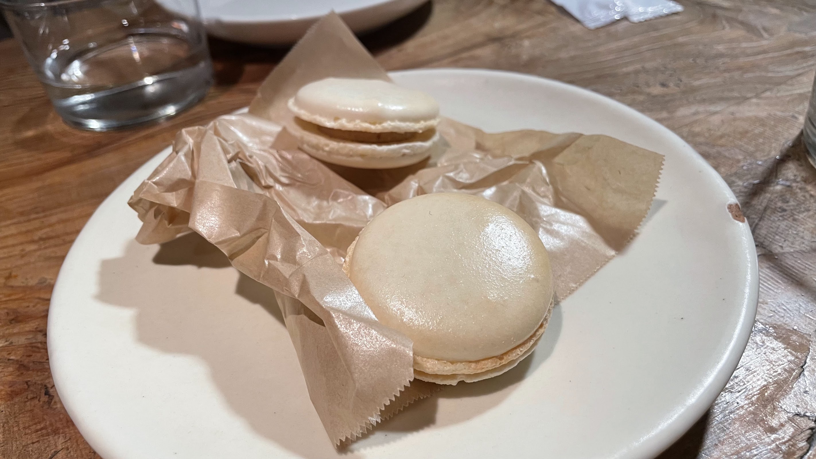 店内のテーブルに置かれた料理と、薄暗い照明に照らされる三軒茶屋のフレンチビストロの一場面